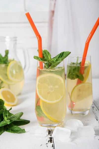 Refrescante bebida fría de verano con limón y menta en respaldo de madera —  Fotos de Stock