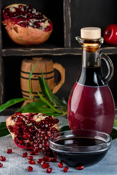 Botella de vidrio y platillo de salsa agria de granada con rip fresco — Foto de Stock