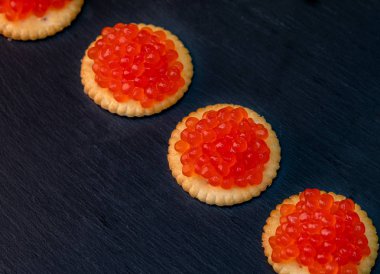 Koyu arkaplanda kırmızı havyarlı tart