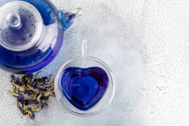 Bir fincan Kelebek Bezelye çayı (bezelye çiçeği, mavi bezelye) ve sağlıklı içme için çaydanlık, açık arkaplanda detoks içme