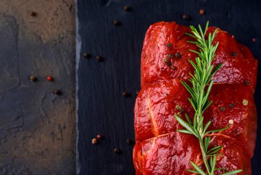 Çiğ et. Biberiyeli ve arka planda baharatlı büyük bir biftek dilimi.