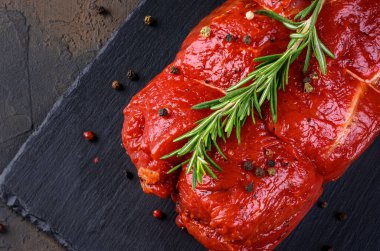 Çiğ et. Biberiyeli ve arka planda baharatlı büyük bir biftek dilimi.