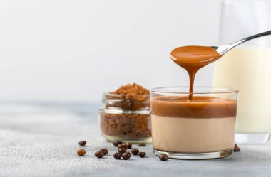 Dalgona köpüklü kahve trend Kore latte espresso açık arkaplanda cam bardak köpüklü kahve