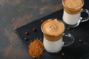 İki bardak Dalgona köpüklü kahve. Kore kahvesi. Siyah arka planda kahve köpüklü espresso.