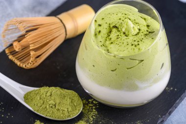 Dalgona Matcha Latte, kremalı bir kibrit, açık arkaplanda. Kibrit yeşil çay.