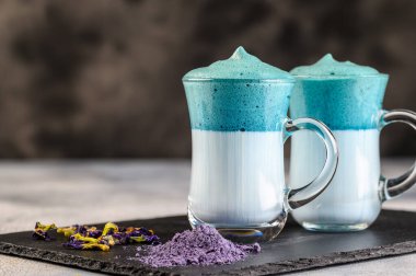 Dalgona Matcha Blue Latte, açık arkaplanda cam kırbaçlanmış kremalı kibrit.. 