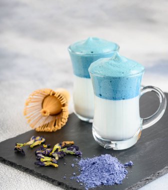 Dalgona Matcha Blue Latte, açık arkaplanda cam kırbaçlanmış kremalı kibrit.. 
