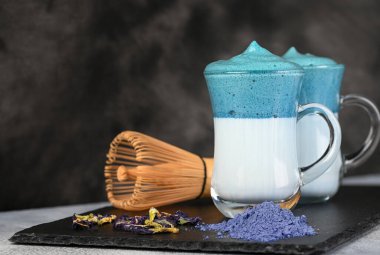 Dalgona Matcha Blue Latte, koyu arkaplanda kremalı bir kibrit.. 