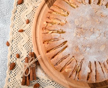 Ev yapımı organik elmalı turta, badem ve tarçınlı. Yemeye hazır tatlı. Işık arkaplanındaki üst görünüm