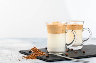 Two glass cups with Dalgona frothy coffee trend korean drink latte espresso with coffee foam on light background clipart