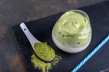 Dalgona Matcha Latte, koyu arkaplanda kremalı bir kibrit. Kibrit yeşil çay.