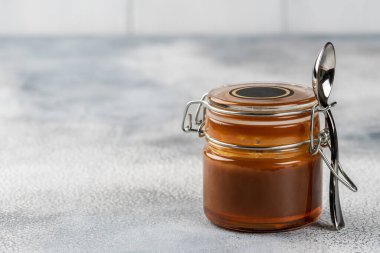 Ev yapımı tuzlu karamel sosu. Seçici odaklanma, metin için boşluk. Hafif arkaplanda