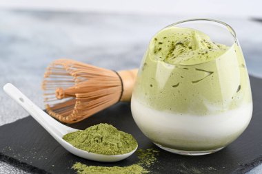 Dalgona Matcha Latte, kremalı bir kibrit, açık arkaplanda. Kibrit yeşil çay.