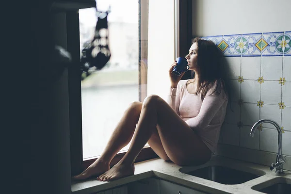 Girl sitting in window — Stock Photo, Image