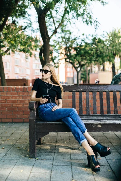 Meisje in zonnebril bezit smartphone — Stockfoto