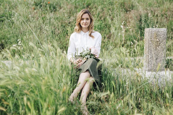 Girl sitting in tall grass — Stock Photo