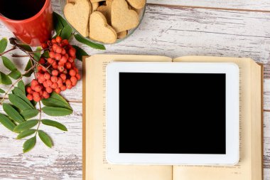 Modern tablet. Eski kitap. Rowan şube. Zencefilli kurabiye Kalpler