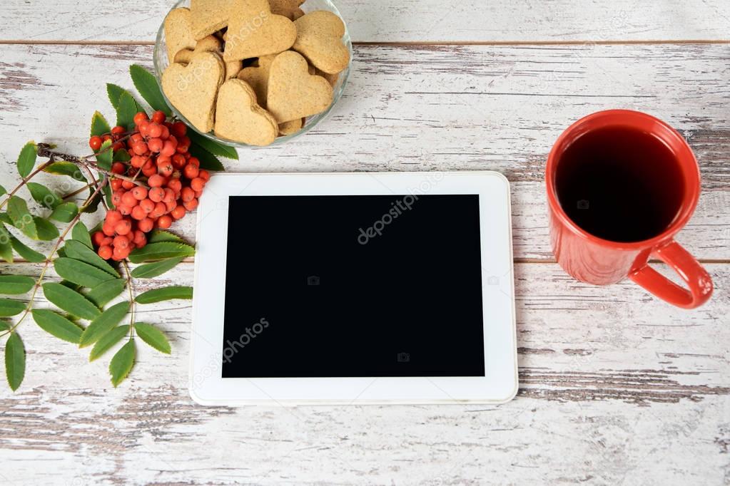 Ginger cookies hearts. Modern tablet. Rowan branch