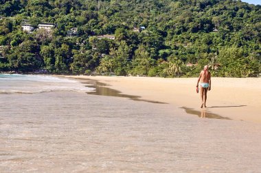 Yaşlı adam. Plaj boyunca yürüyüş. Sıcak kum