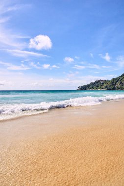 Mavi deniz. Açık gökyüzü. Beyaz dalgalar. Yeşil dağ