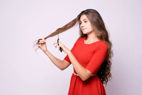 Dziewczynka Fryzjer. Długie włosy. Czerwona sukienka. Czarny nożyce — Zdjęcie stockowe