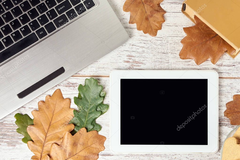 Autumn leaves. Modern tablet. Gray notebook