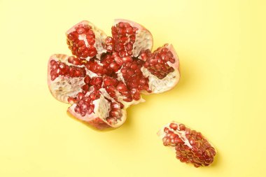 Kıyılmış meyve. Nar dilimleri. Küçük kırmızı tahıl. Sarı arka plan