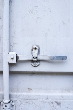 Açık gri renkli. Kapalı kapı. Demir kilit