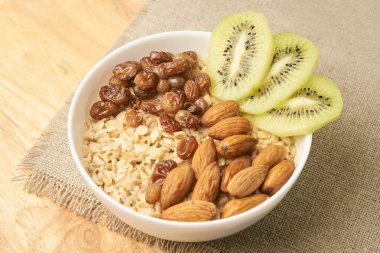 Nötr arka plan. Yulaf ezmesi kivi kuru üzüm ve badem