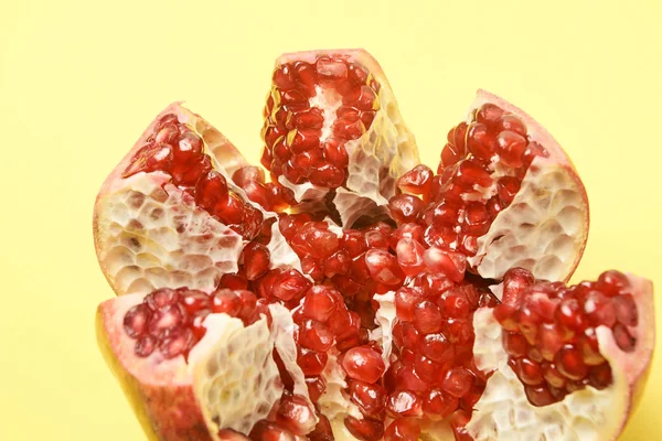 Chopped fruit. Small red grains. Pomegranate slices. Yellow background