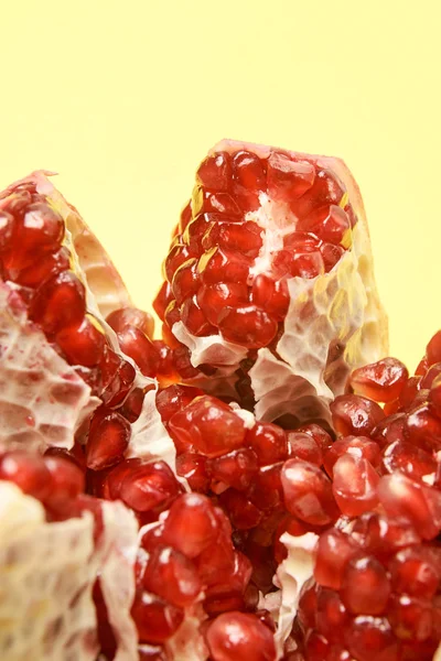 Chopped fruit. Small red grains. Yellow background. Pomegranate slices