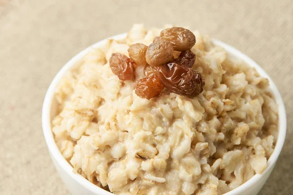 Delicious healthy breakfast. Oatmeal with raisins. Neutral background — Stock Photo, Image