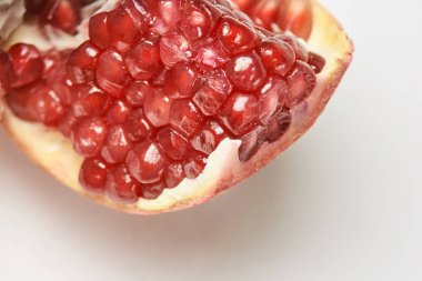 Olgun parlak Granat. Beyaz arka plan. Kırmızı nar taneleri