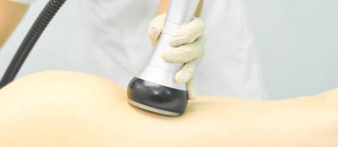 Süpürge masaj aleti. Selülit önleyici vücut düzeltme tedavisi. Zayıflama aleti. Tıp salonundaki kadın ve doktor.