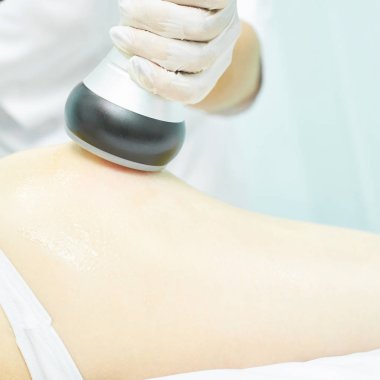 Süpürge masaj aleti. Selülit önleyici vücut düzeltme tedavisi. Zayıflama aleti. Tıp salonundaki kadın ve doktor.