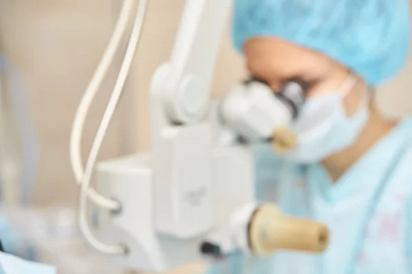 Operação de microscópio a laser oftalmológico. Sala da clínica com médico e parente. Contexto azul. Desfoco, foco seletivo — Fotografia de Stock