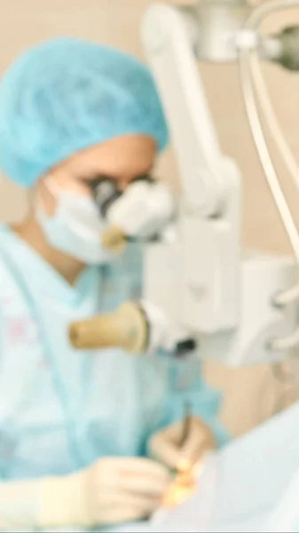 Operação de microscópio a laser oftalmológico. Sala da clínica com médico e parente. Contexto azul. Desfoco, foco seletivo — Fotografia de Stock