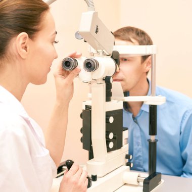 Optisyen doktor, erkek hastayla birlikte muayene laboratuvarında. Erkekler tıbbi teşhisi göz kulak olur. Göz kapağı tedavisi