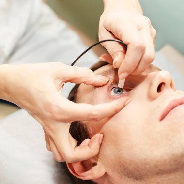 Optisyen doktor, erkek hastayla birlikte muayene laboratuvarında. Erkekler tıbbi teşhisi göz kulak olur. Göz kapağı tedavisi
