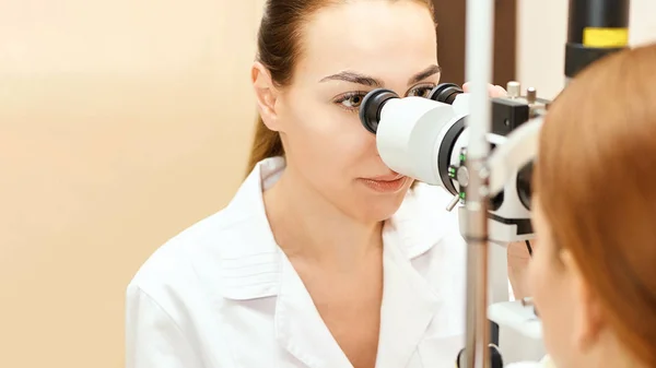 Oftalmólogo médico en laboratorio óptico examen con paciente femenino. Diagnóstico médico del cuidado ocular. Tratamiento de párpados —  Fotos de Stock