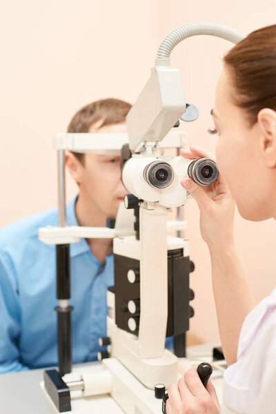 ophthalmologist doctor in exam optician laboratory with male patient. Men eye care medical diagnostic. Eyelid treatment