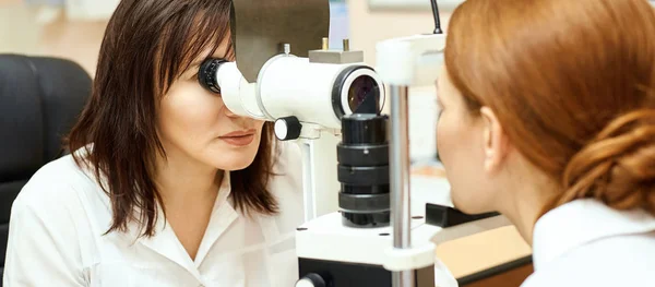 Ophthalmologist doctor in exam optician laboratory with female patient. Eye care medical diagnostic. Eyelid treatment — Stock Photo, Image