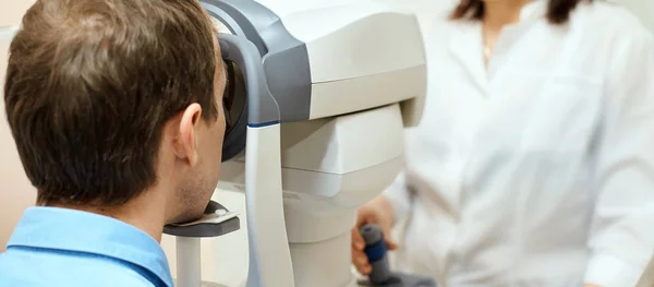 ophthalmologist doctor in exam optician laboratory with male patient. Men eye care medical diagnostic. Eyelid treatment