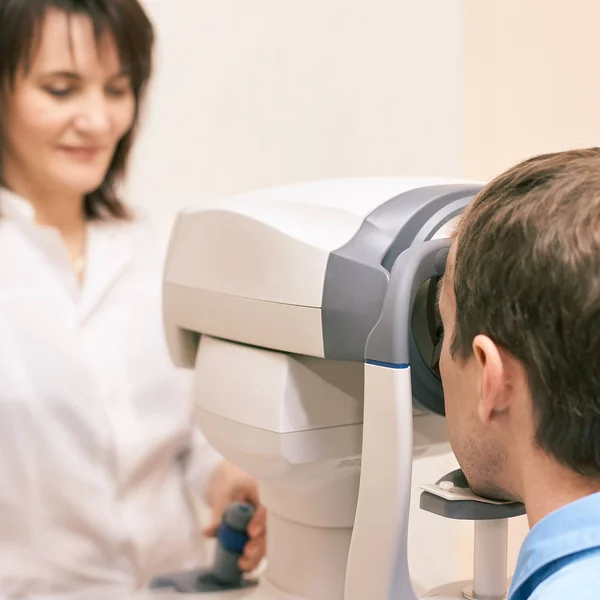 Oogheelkundige arts in het laboratorium van de onderzoeksopticien met mannelijke patiënt. Mannen oogzorg medische diagnostiek. Ooglidbehandeling — Stockfoto