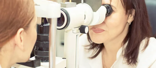 眼科医生与女病人一起在眼科检查光学实验室工作。眼科医疗诊断。眼睑治疗 — 图库照片