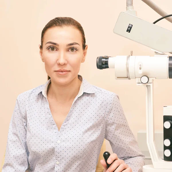 Ophthalmologist doctor in exam optician laboratory with female patient