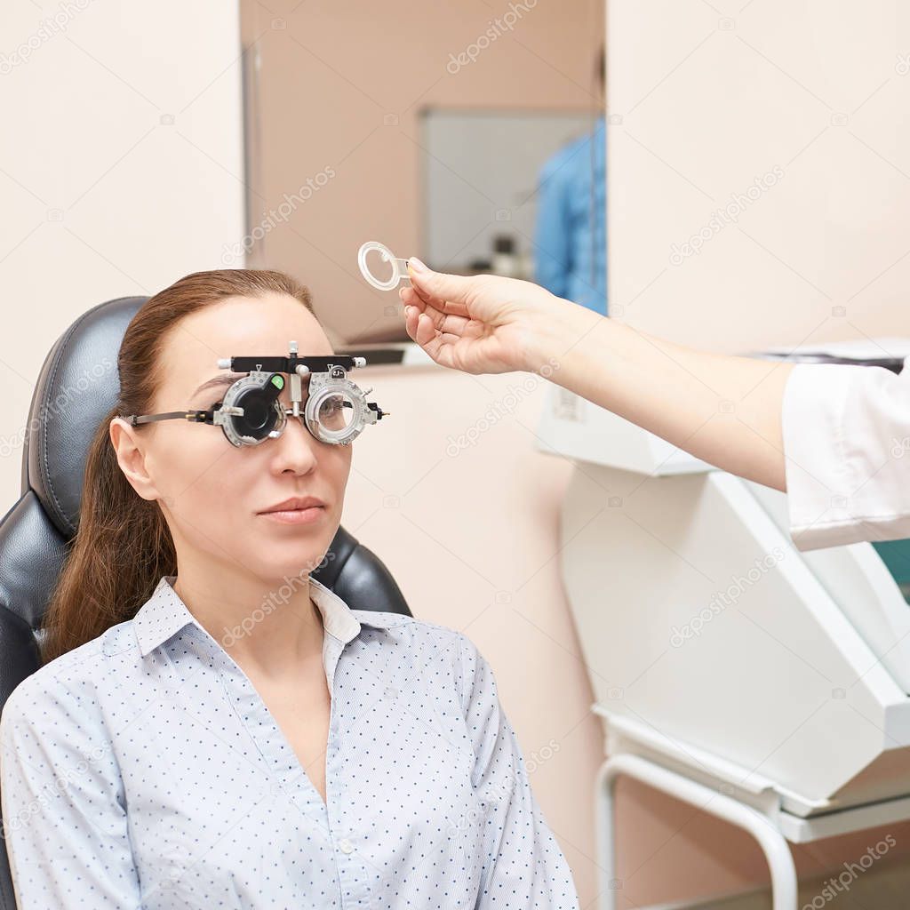 ophthalmologist doctor in exam optician laboratory with female patient. Eye care medical diagnostic. Eyelid treatment