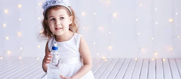 Młoda dziewczynka trzyma butelkę wody. Dzieciak pije świeżo. Spragniona kobieta — Zdjęcie stockowe