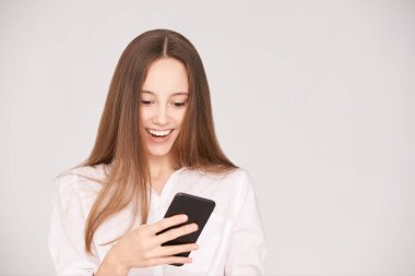 SMS yazan mutlu genç kız. Akıllı telefon. Vay canına. Stüdyodaki kadın model. Bayan şaşırmış portre. Gizli satış