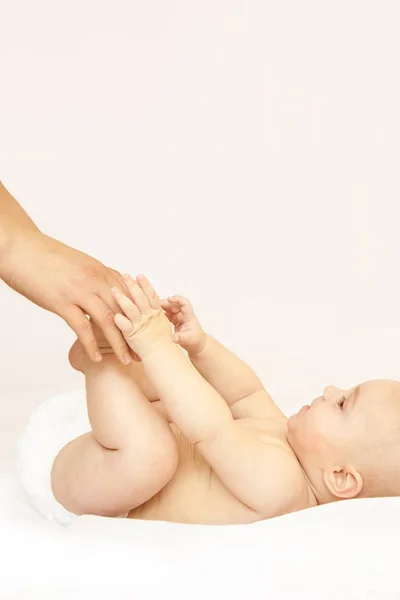 Pasgeboren jongen, moederhand. Babymoeder massage. Grappige kinderen verschonen luier. Thuis servet — Stockfoto